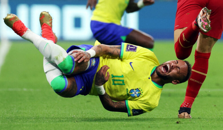 imagem do jogador neymar levando um tombo no gramado de futebol enquando faz cara de dor