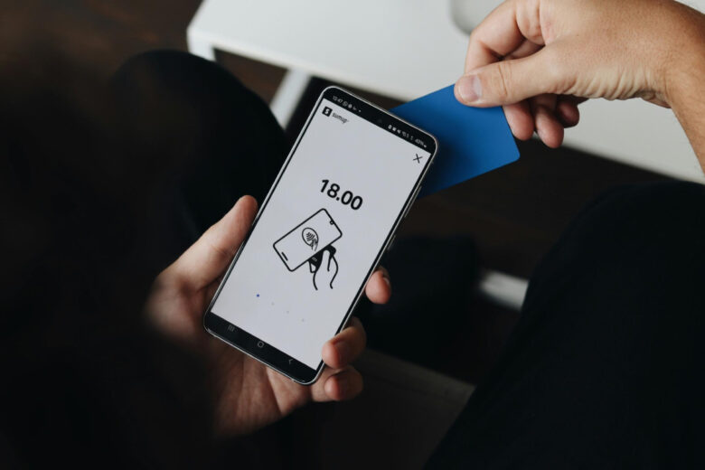 Como os pagamentos invisíveis mudaram os apps de lazer Imagem mostrando um pagamento sendo efetuado pelo celular