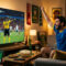 Homem assistindo a um jogo de futebol na TV, torcendo para o árbitro.